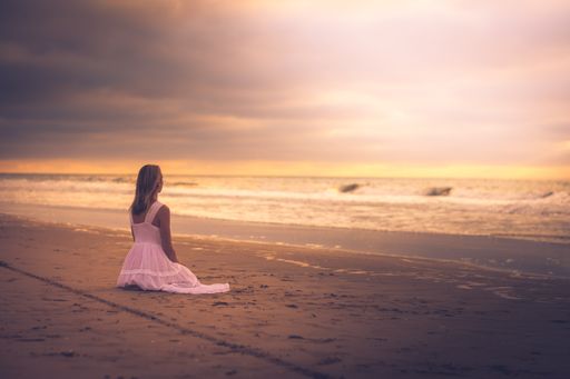 A beautiful shot of a female posing at a beach during the sunset