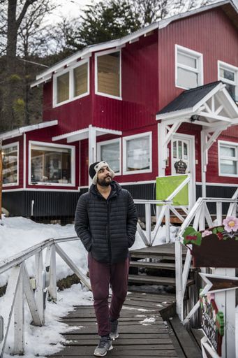 A selective focus shot of a young Hispanic male walking in a neighborhood in winter