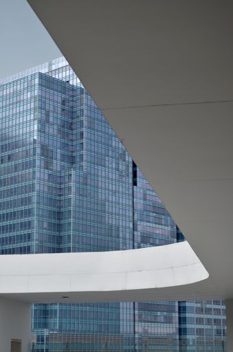 A low angle vertical shot of a white slide covering the high rise glass building