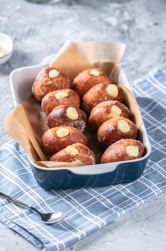 A vertical shot of sweet desserts in a blue plate on a blue patterned tablecloth