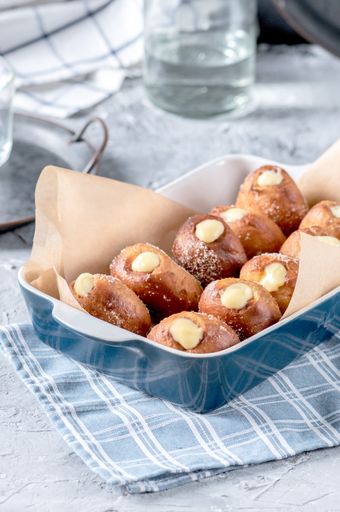 A vertical shot of sweet desserts in a blue plate on a blue patterned tablecloth