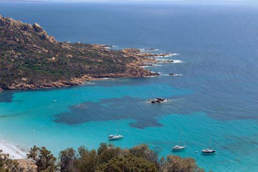 An aerial view of the harbor in the sea captured from the high cliff in summer
