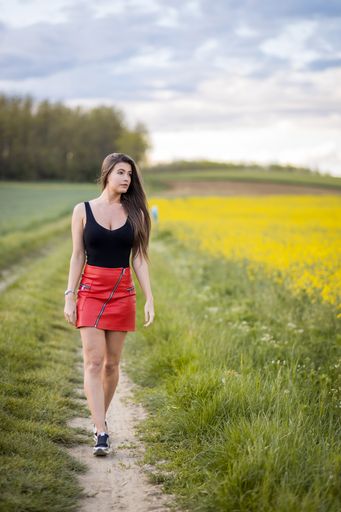 A beautiful Caucasian girl from Hungary posing in a field with yellow flowers