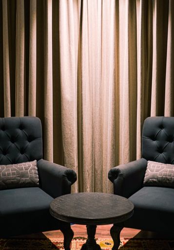 A vertical shot of two armchairs near a small table
