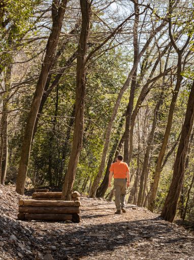 A closeup shot of the man walking on a path in the forest