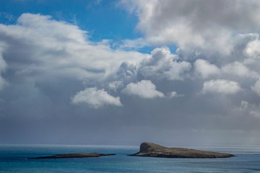 A beautiful scenery of rocky cliffs by the sea under a cloudy sky