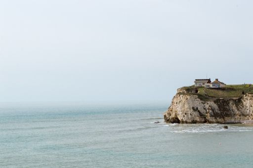 A beautiful scenery of a rocky cliff with buildings in the west part of Isle of Wight