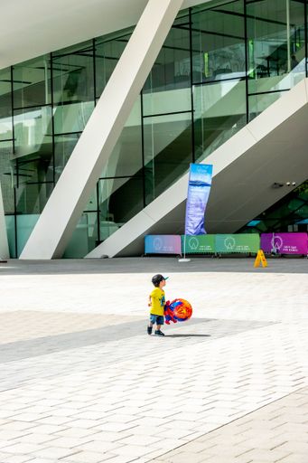 A vertical shot of a boy kid walking around the Bluewaters Island, Marina, Dubai, United Arab Emirates