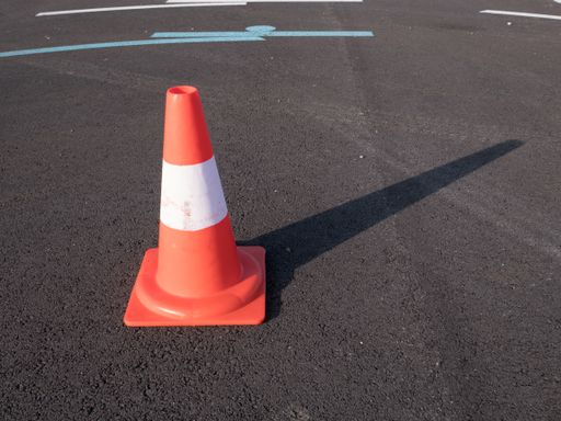 A traffic cone with shadow on asphalt