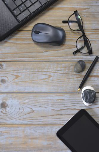 The laptop, digital tablet with a wireless mouse, optical eyeglasses and pebble stones isolated on a wooden surface - work at home concept