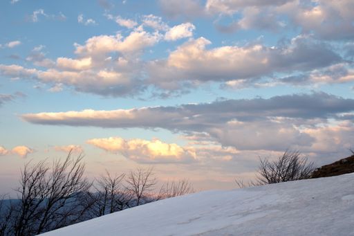 A breathtaking view of a blue sky captured from a snow covered mountain