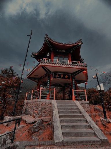 a low angle shot of japanese red building agaisnt cloudy sky