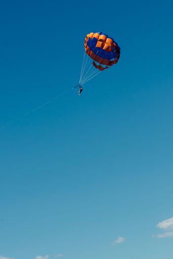 A vertical shot of tourists enjoying parasailing in Algarve, Portugal