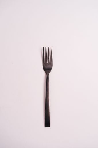 A closeup shot of a metal fork isolated on a light-colored background