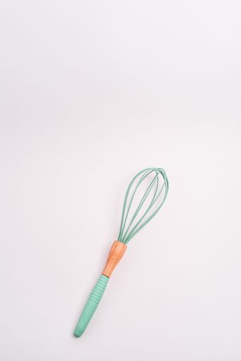 A vertical closeup shot of a green whisk isolated on a white background