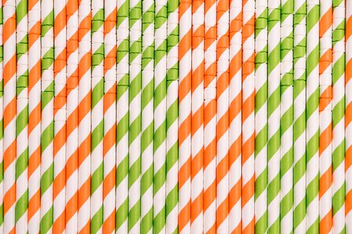 A closeup shot of green, red, and white striped drinking tubes scattered vertically on the surface