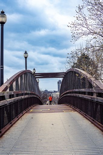 A vertical shot of a rusty old iron walkway bridge on the train tracks