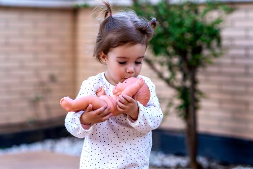 child girl kissing her doll