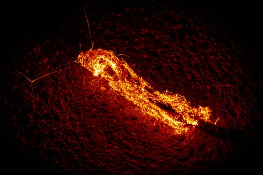 A Closeup of a burning hot fire on an asphalt