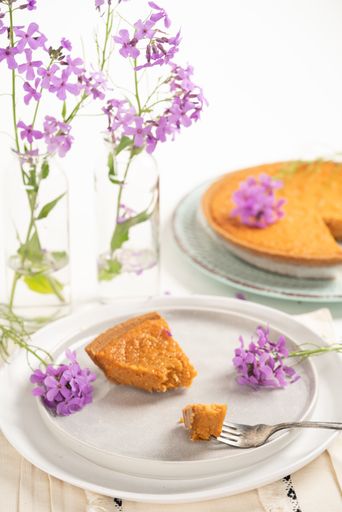 A vertical shot of sweet potato pie slices with graham cracker crust on plates