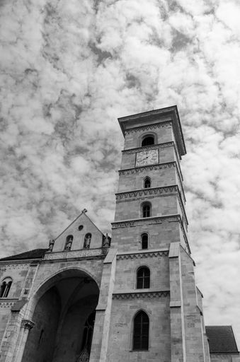 A vertical grayscale shot of a St. Michael's Cathedral against the cloudy sky. Alba Iulia, Romania.