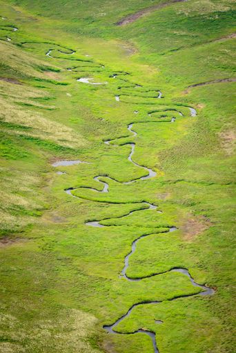 A vertical high angle shot of a waterfall in the mountains of Kamchatka