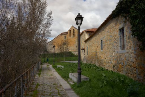 A Hispanic woman standing near the old buildings in Avila, Spain
