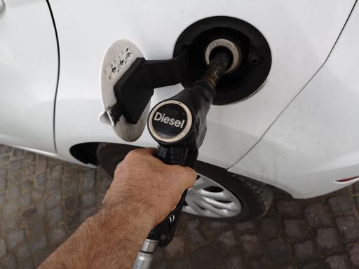 A top view of a man filling the car tank with diesel fuel at the gasoline station