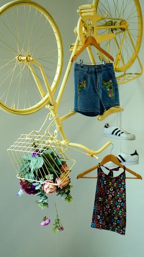A shot of a yellow upside-down bicycle with items of clothing