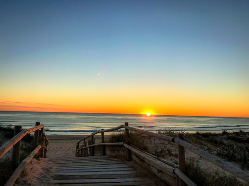 precioso atardecer en la playa con el mar mediterráneo en calma visto desde el puente de madera