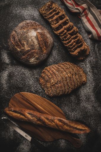 A top view of a freshly baked bread assortment on a black table