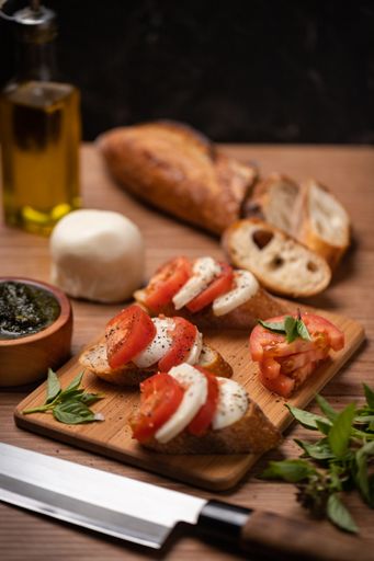 The bruschetta with tomatoes, basil and mozzarella on a wooden table