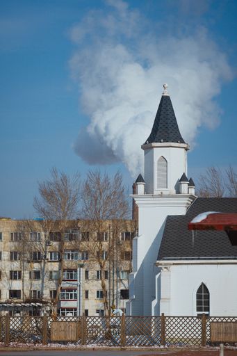 A vertical shot of the McDowell UMC Pontiac church under a cloudy sky
