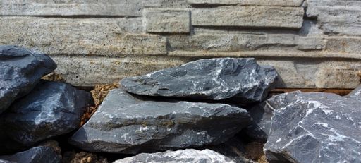 gray brown wall behind dark gray pattern stones