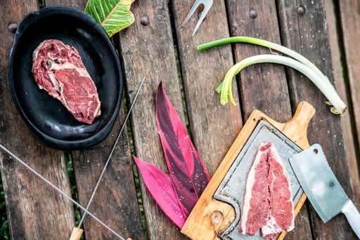 A piece of raw beef steak with herbs and spices from above