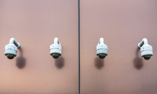 A closeup shot of four white lamps on the two sides of a beige wall