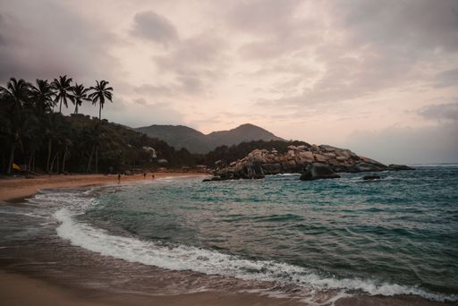 Dramatic scenery of gloomy cloudy sky over wavy sea and sandy beach