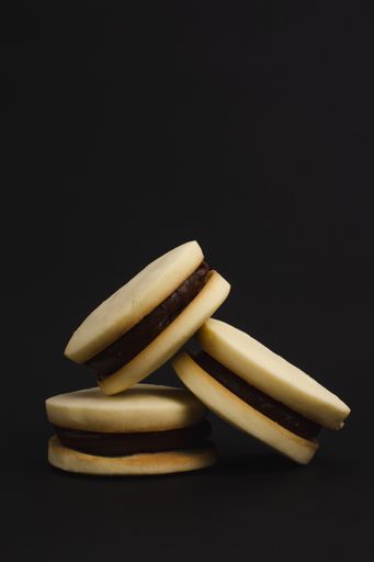 A vertical closeup of chocolate cookies against a black background