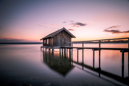 A beautiful view of a boathouse over Ammersee lake against the sunset sky in Bavaria, Germany