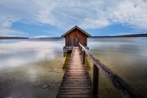 An old boathouse at lake Ammersee in Bavaria, Germany against a cloudy sky
