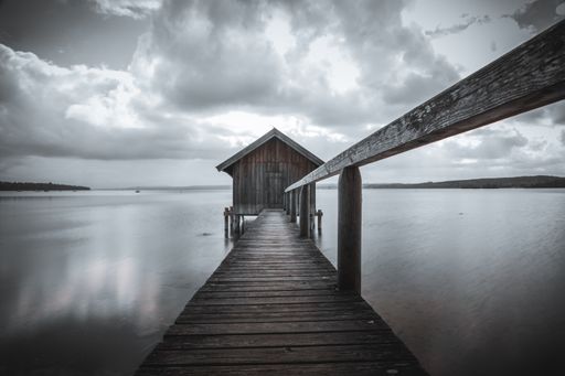 An old boathouse at lake Ammersee in Bavaria, Germany against a cloudy sky