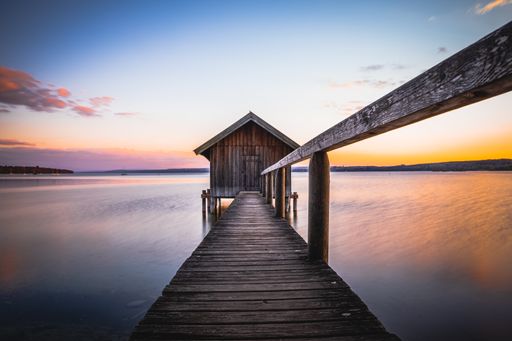 An old boathouse at lake Ammersee in Bavaria, Germany against the sunset