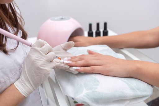 A woman in beauty center performing a nail service and beautification of hands and nails
