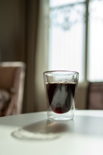 A vertical shot of a glass of coffee on the table