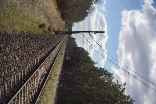 A vertical shot of old railways in a rural area in cloudy sky background