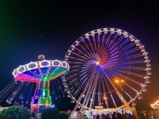 A scenic view of neon Ferris wheel in park