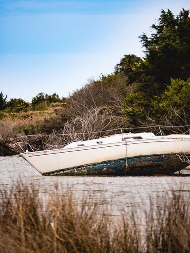 A vertical shot of a boat at a beach during the day