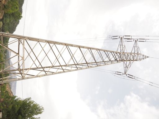 A low angle shot of high voltage power lines during a cloudy day