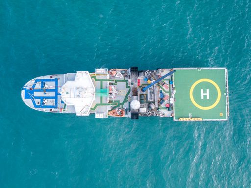 Offshore vessel aerial photo at South Atlantic.  Survey vessel from above. Safety walkways on board offshore vessel. Helicopter landing deck.