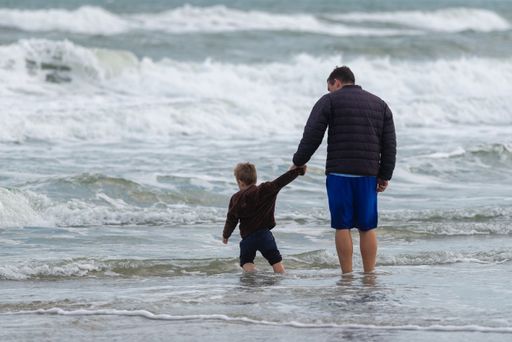The father and son checking out the incoming waves at the beach